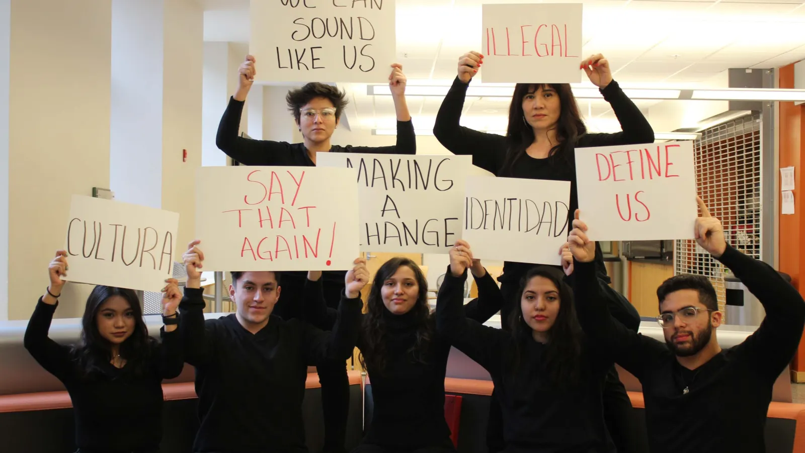 Students holding signs "We can sound like us"