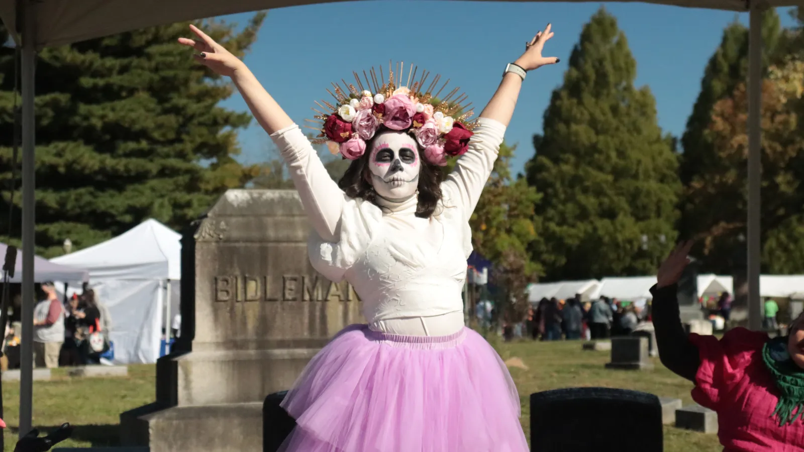 Woman in skeleton costume in front of gravestone