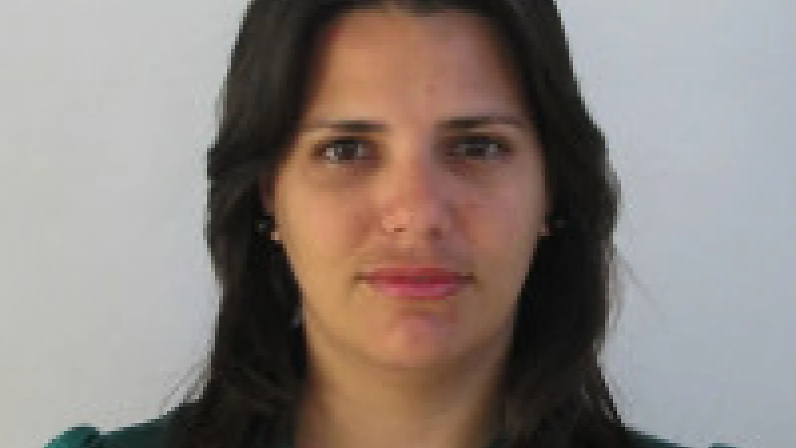 A person with long, dark brown hair looking at the camera