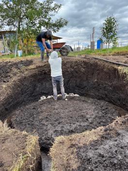 a photograph of people working on the base of the first of the vermicompost system