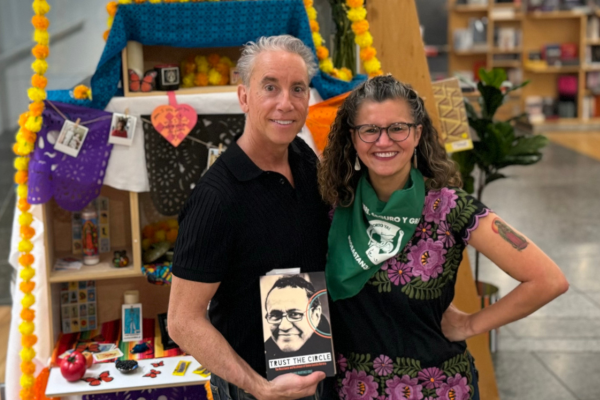 A man and a woman standing in front of an alter for day of the dead