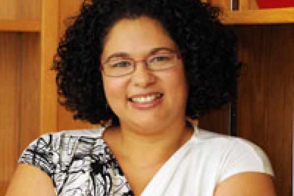 Photo of Sujey Vega, a brown-skinned woman with curly black hair